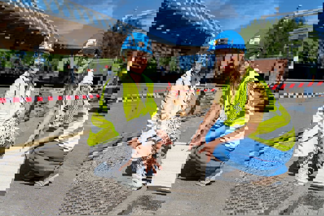 Konsernsjef i Sporveien, Birte Sjule og byråd for miljø og samferdsel, Sirin Stav, legger ned den aller første ledelinjesteinen som skal hjelpe blinde og svaksynte å lettere reise med T-banen fra Mortensrud T-banestasjon. Foto: Sporveien