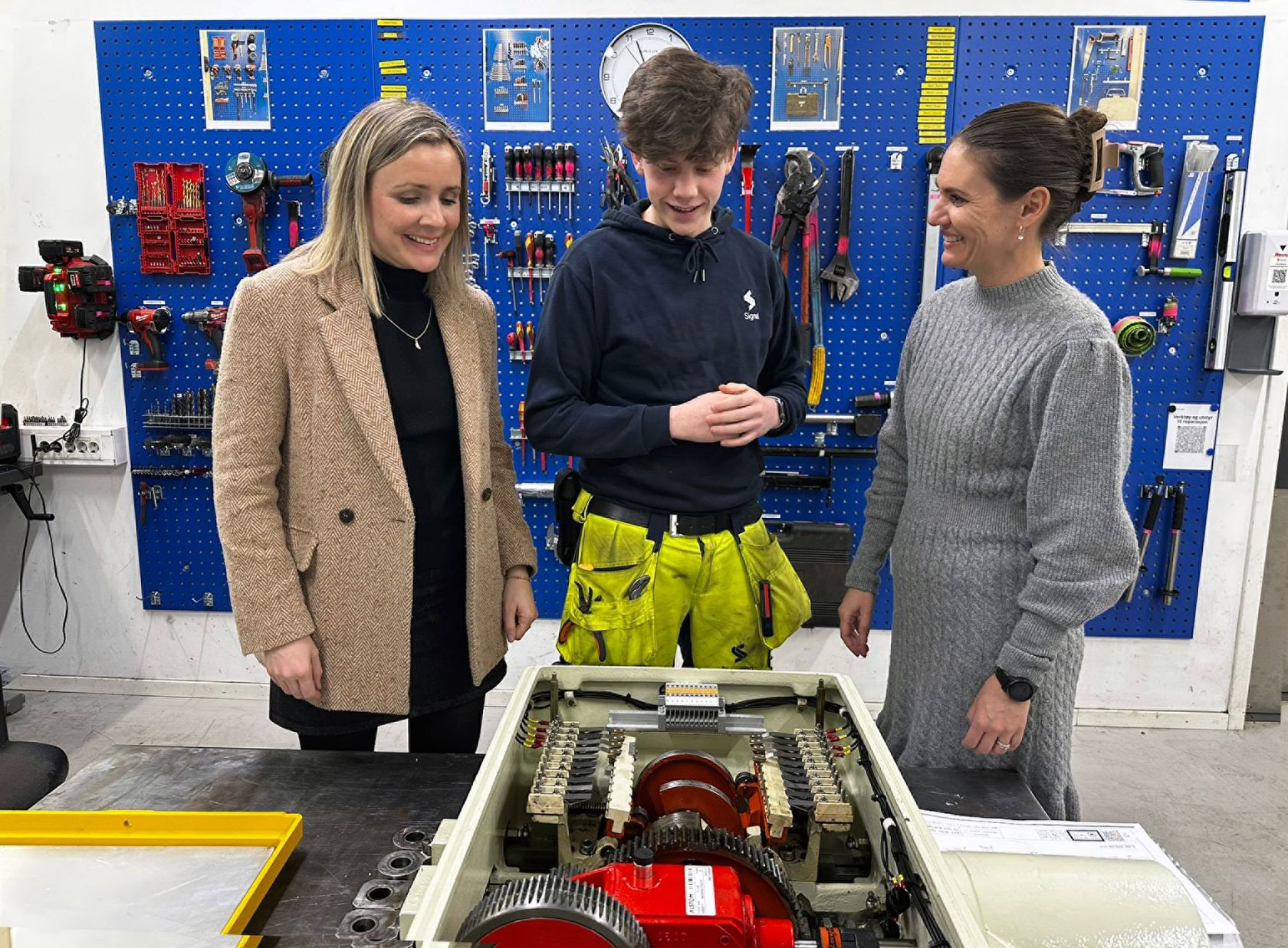 Sporveiens signalmontørlærling, Herman Osvold Askheim forklarer  byråd for miljø og samferdsel Marit Vea (V) og byråd for utdanning Julie Remen Midtgarden (H) om signalsystemet og demonstrerte hvordan en drivmaskin fungerer mekanisk.