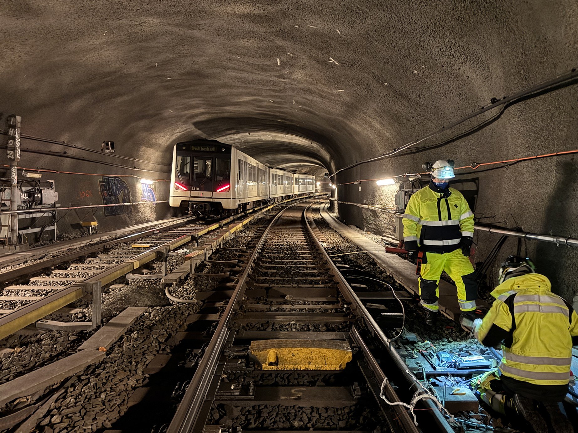 Arbeidere som installerer nytt det nye signalsystemet i tunnel. 
